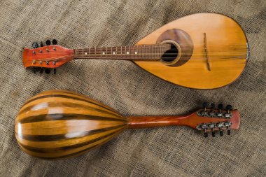 İki eski mandolin kaba çuval bezi doku bir arka plan üzerinde. Farklı açılardan görüntüleme.