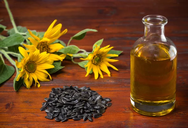 Sonnenblumenöl Einer Glasflasche Und Eine Handvoll Sonnenblumenkerne Auf Dem Hintergrund — Stockfoto