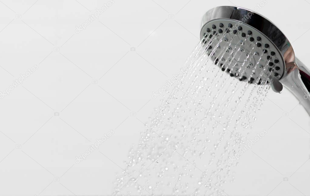 Jets of water flow from the shower head. Selective focus.