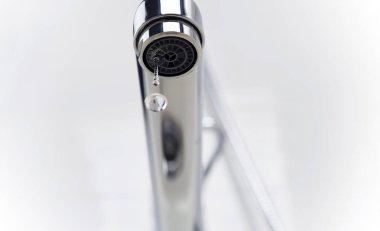 Musluktan damlayan bir damla saf su. Seçici odak.