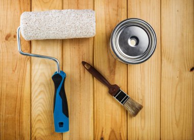 Boya fırçası, boya ve boya silindiri ahşap arka plan üzerinde konservesi