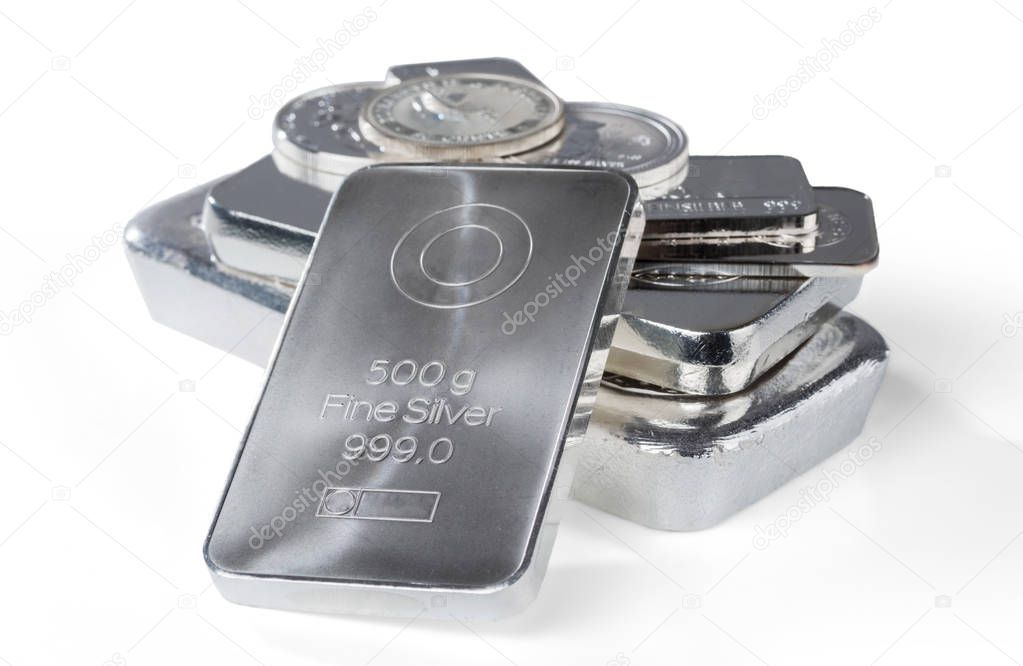 Silver bullion. Cast and minted bars and coins isolated on white background. Selective focus.