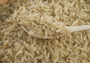 Beyaz arka planda izole kahverengi soyulmuş pirinç avuç. 