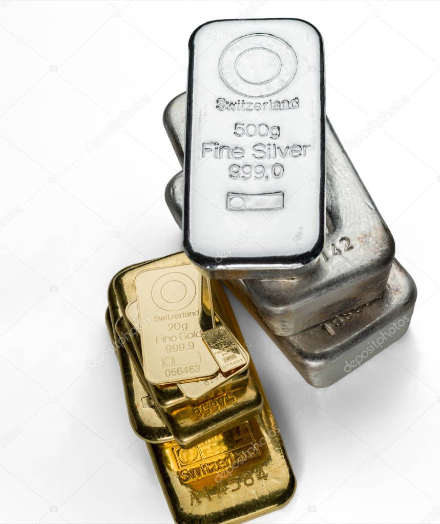 Several gold and silver bars of different weight are isolated on a white background. Selective focus.