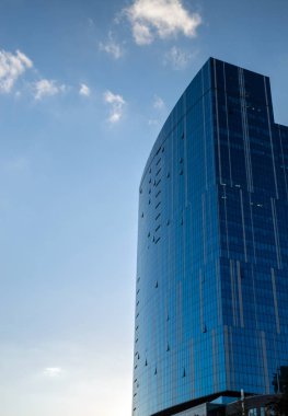 Bulutlar ile mavi gökyüzüne karşı cam ve beton Modern bina.