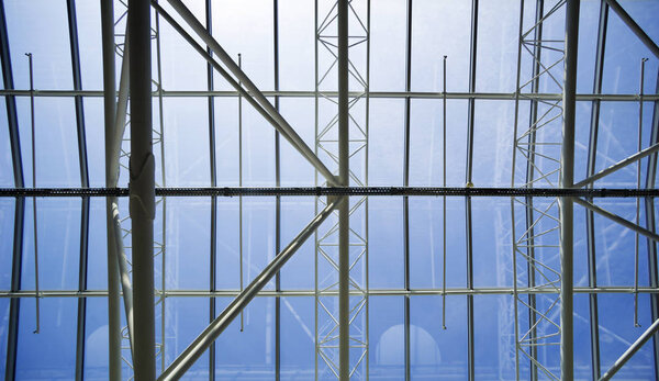 View of the blue sky through the glass roof of the building.