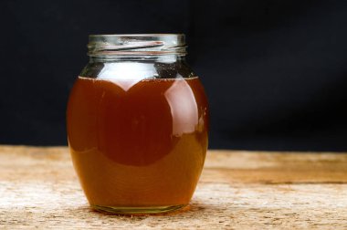 Taze hazırlanmış Ghee tereyağı ile yuvarlak cam kavanoz. Karanlık bir arka planda.