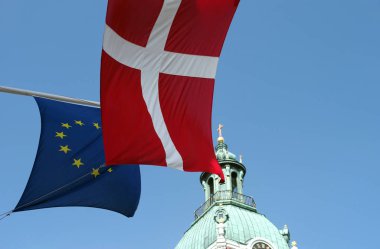 Katedralin kubbesi ve mavi gökyüzüne karşı Danimarka bayrağı ve Avrupa Birliği bayrağı parçaları.
