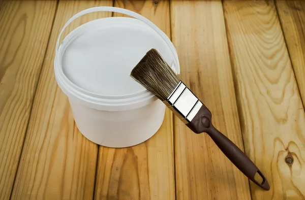 木製の板のデッキに塗料の白い缶にペイントブラシ — ストック写真