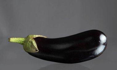 Gri bir arkaplanda uzun mor patlıcanlar..