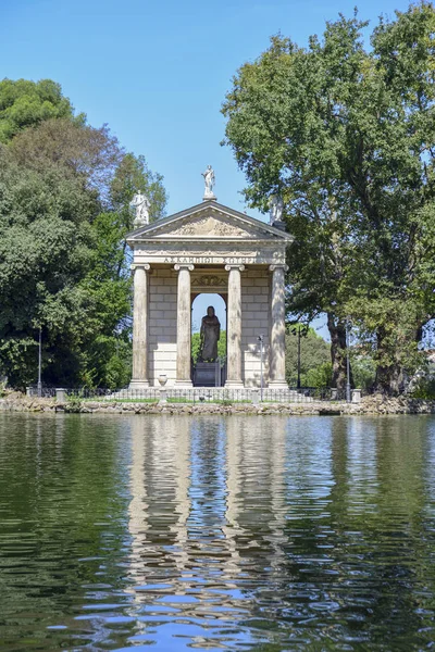 Garden of Villa Borghese. Lake with boats and temple of Esculapio.Rome Italy