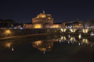 Roma İtalya. Aziz Angelo Kalesi ve köprünün yansımaları ile gece güzel manzarasına Tiber Nehri üzerinde.