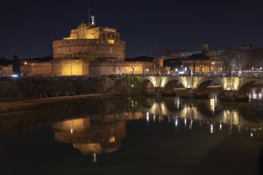 Roma İtalya. Aziz Angelo Kalesi ve köprünün yansımaları ile gece güzel manzarasına Tiber Nehri üzerinde.
