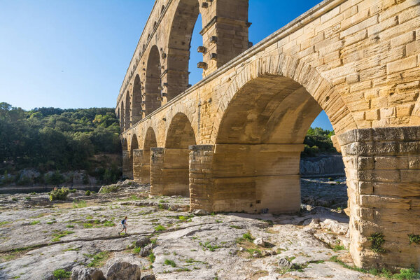 Remoulins , France - august 12, 2016:people swim and canoe near the Pont du Gard Roman aqueduct during a sunny day