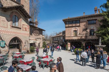 Grazzano Visconti,Italy-April 2,2018:People visit the historical village of Grazzano Visconti,neo-gothic village near Piacenza, Italy during a sunny day clipart