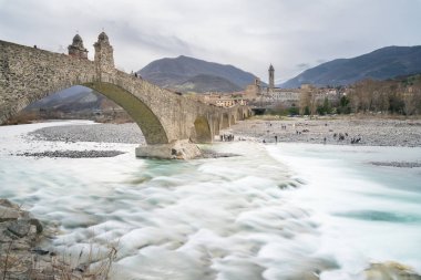 Bir bulutlu gün boyunca aradım Nehri Bobbio küçük kasaba Trebbia Bobbio, İtalya-Nisan 2, 2018:View eski ortaçağ köprünün 'Ponte Gobbo'.