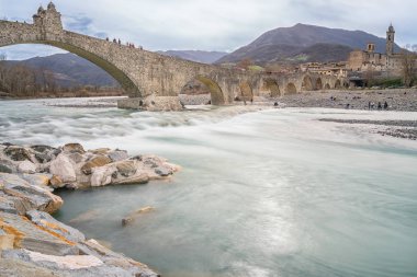 Bir bulutlu gün boyunca aradım Nehri Bobbio küçük kasaba Trebbia Bobbio, İtalya-Nisan 2, 2018:View eski ortaçağ köprünün 'Ponte Gobbo'.