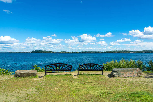 Thousan islands,Canada-august 4,2015:two benches on the banks of the one thousand islands parks in Ontario during a summer day