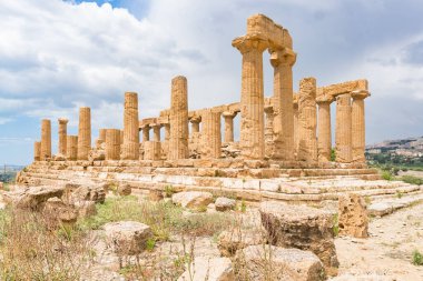 Agrigento, İtalya-10 Mayıs 2022: güneşli bir günde Agrigento yakınlarındaki Valle di Templi arkeoloji parkının içindeki heybetli Yunan Juno Tapınağı