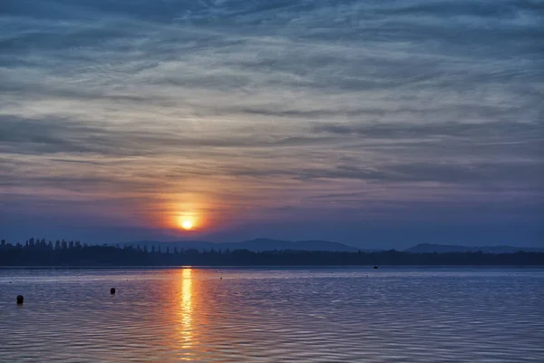 Schöner Sonnenuntergang über dem See mit bewölktem Himmel — Stockfoto