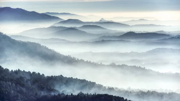 ヴァレーゼの都市の近くの山から見た冬の寒い朝に丘の上の霧の風景 — ストック写真