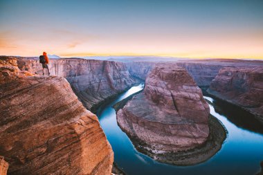 Gün batımında Horseshoe Bend'e bakan yürüyüşçü, Arizona, Abd