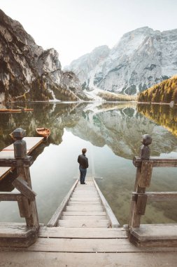 Güney Tyrol, İtalya 'da Lago di Braies' de güneşin doğuşunu izleyen genç adam.