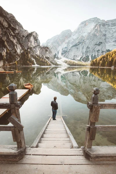 Młody człowiek oglądający wschód słońca w Lago di Braies, Południowy Tyrol, Włochy — Zdjęcie stockowe