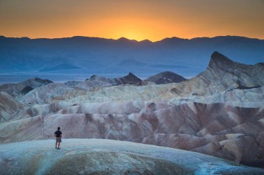 Zabriskie Point'te gün batımının tadını çıkaran yürüyüşçü, Death Valley Ulusal Parkı, ABD