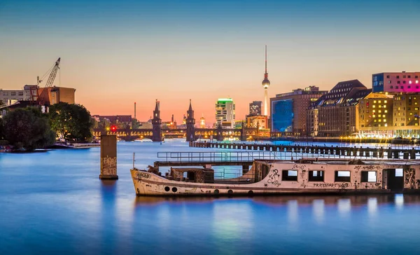 Alacakaranlıkta Spree nehri eski gemi enkazı ile Berlin silueti, Almanya — Stok fotoğraf