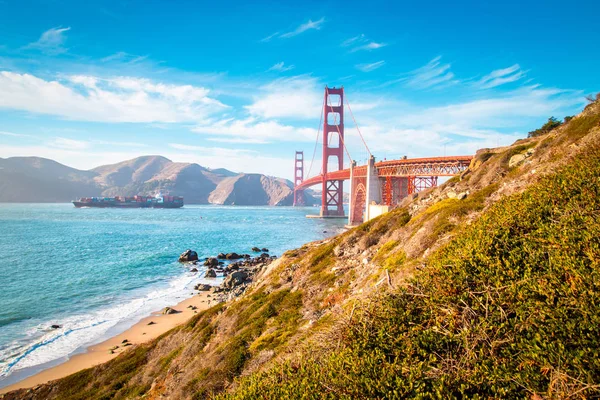 Golden Gate Bridge s nákladní lodí při západu slunce, San Francisco, Kalifornie, USA — Stock fotografie