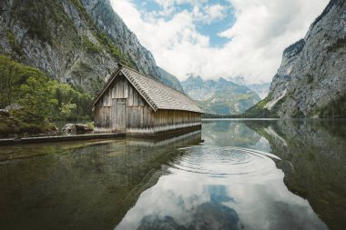 Yaz aylarında mavi gökyüzü ve bulutlar ile güzel bir güneşli bir günde doğal Obersee Gölü'nde geleneksel eski ahşap tekne evi Pastoral görünümü, Millipark Berchtesgadener Land, Bavyera, Almanya