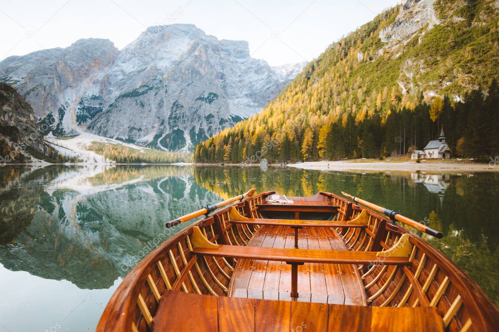 Traditional rowing boat on alpine lake in fall
