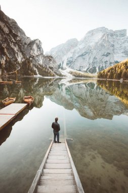 Güney Tyrol, İtalya 'da Lago di Braies' de güneşin doğuşunu izleyen genç adam.