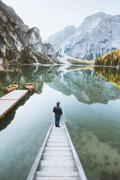 Jongeman kijkt naar zonsopgang in Lago di Braies, Zuid-Tirol, Italië — Stockfoto