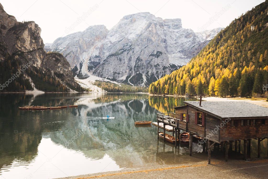 Young man kayaking on Lago di Braies in fall, Dolomites, South Tyrol, Italy