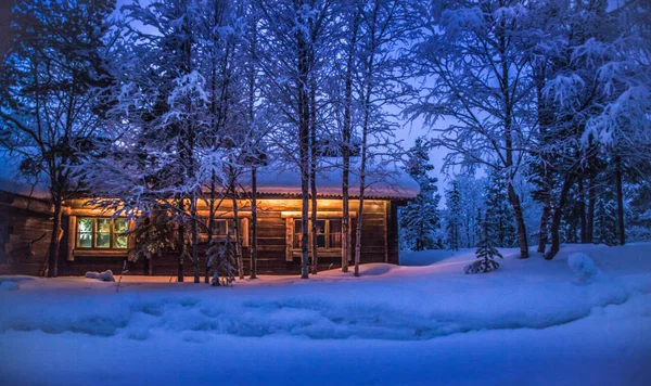 Traditional wooden cabin in winter wonderland at night