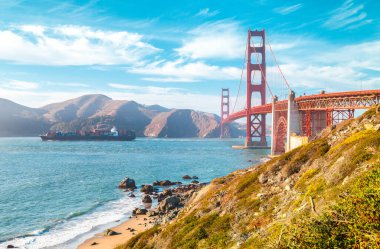 Yaz aylarında mavi gökyüzü ve bulutlar ile güneşli bir günde kargo gemisi ile ünlü Golden Gate Köprüsü Klasik görünümü, San Francisco, Kaliforniya, Abd