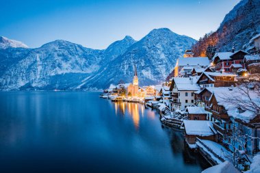 Klasik kartpostal görünümü Alpleri'nde kış, Salzkammergut, Avusturya alacakaranlıkta mavi saat sırasında mistik yazı günbatımı alacakaranlık içinde güzel Hallstattersee ile ünlü Hallstatt lakeside şehrin