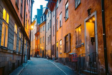 Stockholm 'ün tarihi Gamla Stan' inin (Eski Şehir) güzel sokaklarındaki geleneksel evlerin alacakaranlık manzarası, İsveç 'in merkezi Stockholm' de, alacakaranlıkta mavi saatte aydınlandı.