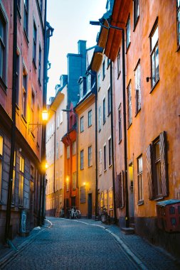 Stockholm 'ün tarihi Gamla Stan' inin (Eski Şehir) güzel sokaklarındaki geleneksel evlerin alacakaranlık manzarası, İsveç 'in merkezi Stockholm' de, alacakaranlıkta mavi saatte aydınlandı.