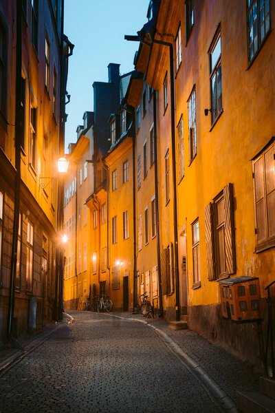Classic twilight view of tradtional houses in beautiful alleyway in Stockholm's historic Gamla Stan (Old Town) illuminated during blue hour at dusk, central Stockholm, Sweden