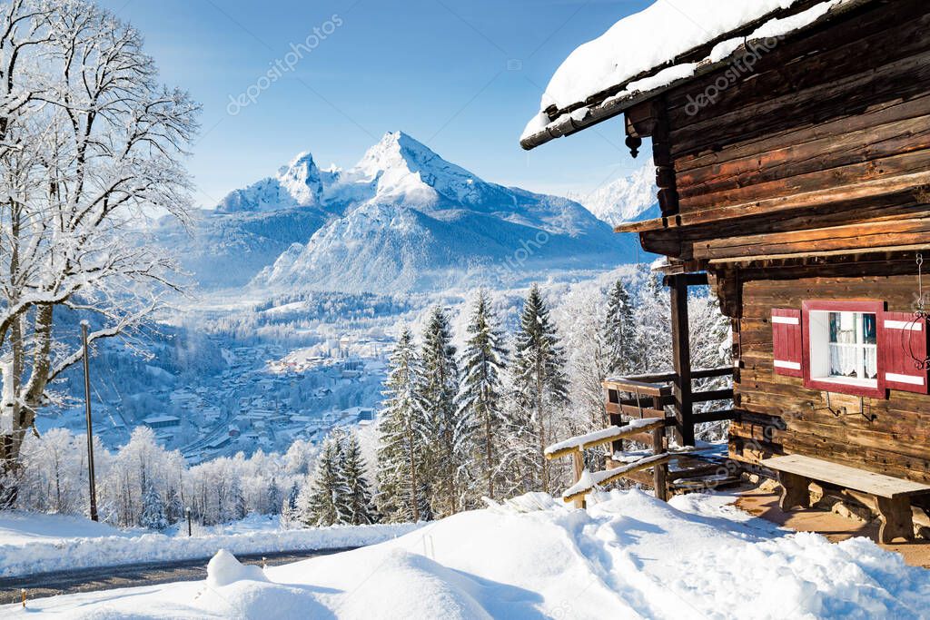 Beautiful view of traditional wooden mountain cabin in scenic winter wonderland mountain scenery in the Alps