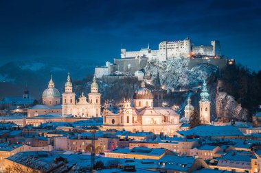 Ünlü Festung Hohensalzburg ve Salzach nehri ile tarihi Salzburg şehrinin klasik manzarası. Kış aylarında güzel bir alacakaranlıkla aydınlanıyor. Salzburger Diyarı, Avusturya.