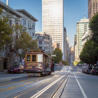 Geleneksel tarihi Cable Car 'ın klasik görüntüsü. Gündoğumunda ünlü Kaliforniya Caddesi' nde eski tarz çapraz işleme filtresi efektiyle birlikte sürüyor. San Francisco, California, ABD