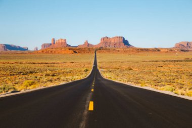 Tarihi ABD Route 163 klasik panorama görünümü yaz aylarında gün batımında güzel altın akşam ışığında ünlü Monument Valley üzerinden çalışan, Utah, Abd