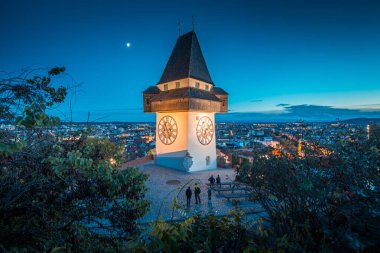 Ünlü Grazer Uhrturm 'un (saat kulesi) güzel alacakaranlık manzarası alacakaranlıkta, Graz, Styria bölgesinde aydınlandı, Avusturya