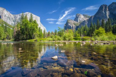 Yosemite Vadisi 'nin klasik manzarası ünlü El Capitan kaya tırmanışı zirvesi ve güneşli bir günde güneşli bir günde güneşli bir nehir, Yosemite Ulusal Parkı, Kaliforniya, ABD