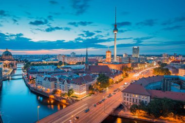 Berlin 'in gökyüzü alacakaranlık manzarası ünlü TV kulesi ve Spree nehri ile aydınlandı. Alacakaranlıkta dramatik bulutlarla aydınlandı, Almanya
