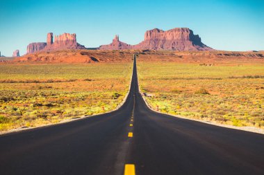 Tarihi ABD Route 163 klasik panorama görünümü yaz aylarında gün batımında güzel altın akşam ışığında ünlü Monument Valley üzerinden çalışan, Utah, Abd